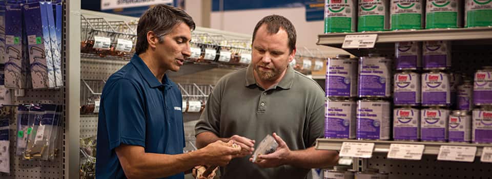 A Ferguson associate at an HVAC Counter location discusses an HVAC part with a contractor.