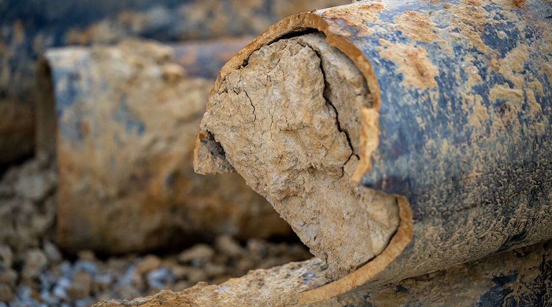 Close-up of a stack of rust- and dirt-covered pipe.