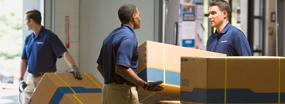 A Ferguson associate carries a box in the warehouse.